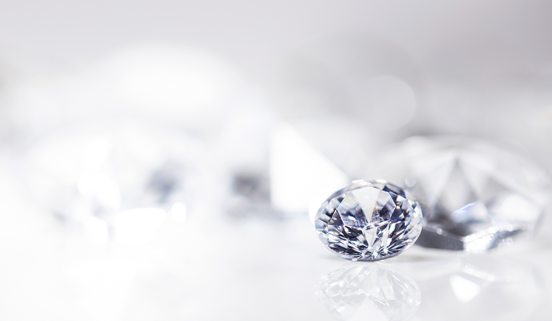 A large diamond is positioned above a group of diamonds, emphasizing their sparkling allure and exquisite design.